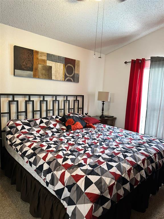 242 Durango Loop Street Davenport, FL 33897 - Photo 20 of 30 a bed sitting in a bedroom next to a window with pc on the wall