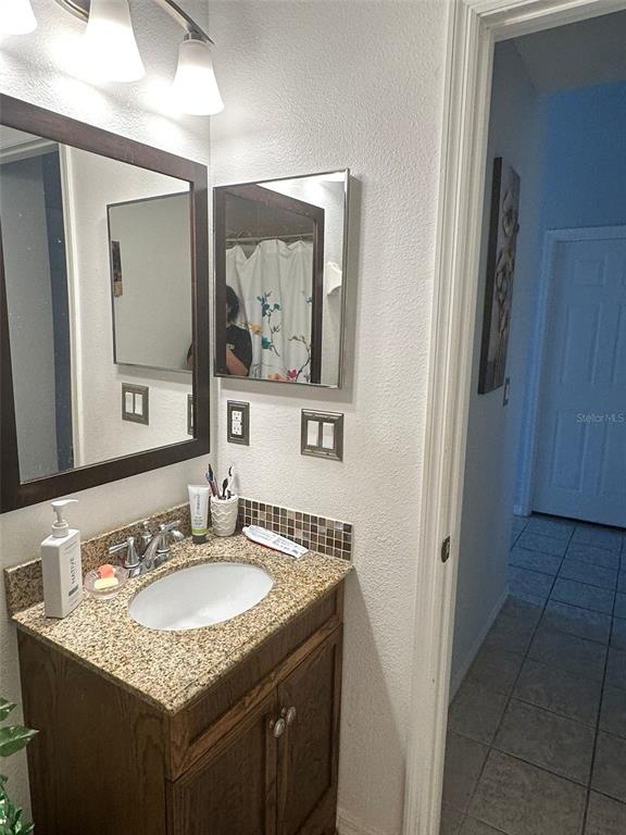 242 Durango Loop Street Davenport, FL 33897 - Photo 9 of 30 a bathroom with a granite countertop sink and a mirror
