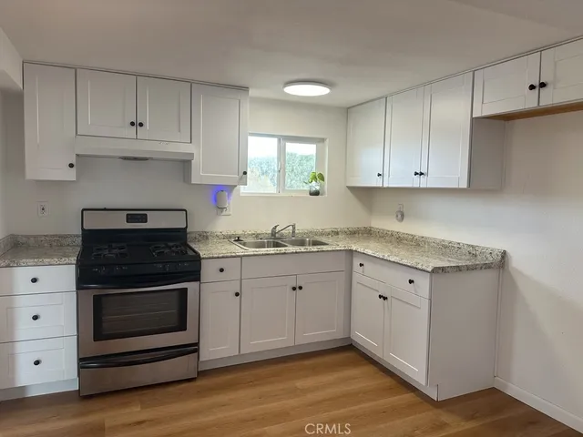 a kitchen with granite countertop white cabinets and white appliances