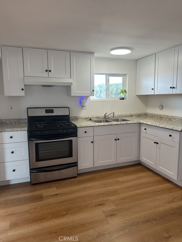 34929 Cedar Road Barstow, CA 92311 - Photo 7 of 22 a kitchen with granite countertop white cabinets and white appliances