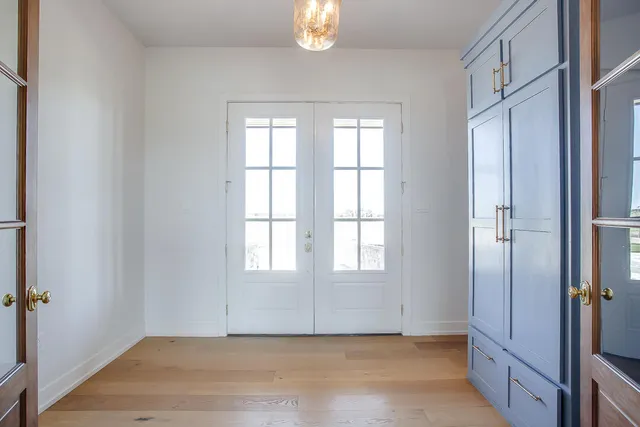 an empty room with windows closet and chandelier