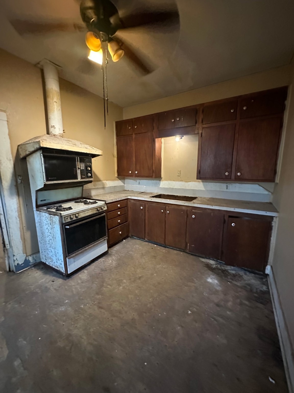 845 Saxe Street Beaumont, TX 77705 - Photo 2 of 7 a kitchen with stainless steel appliances a sink a stove a microwave and cabinets