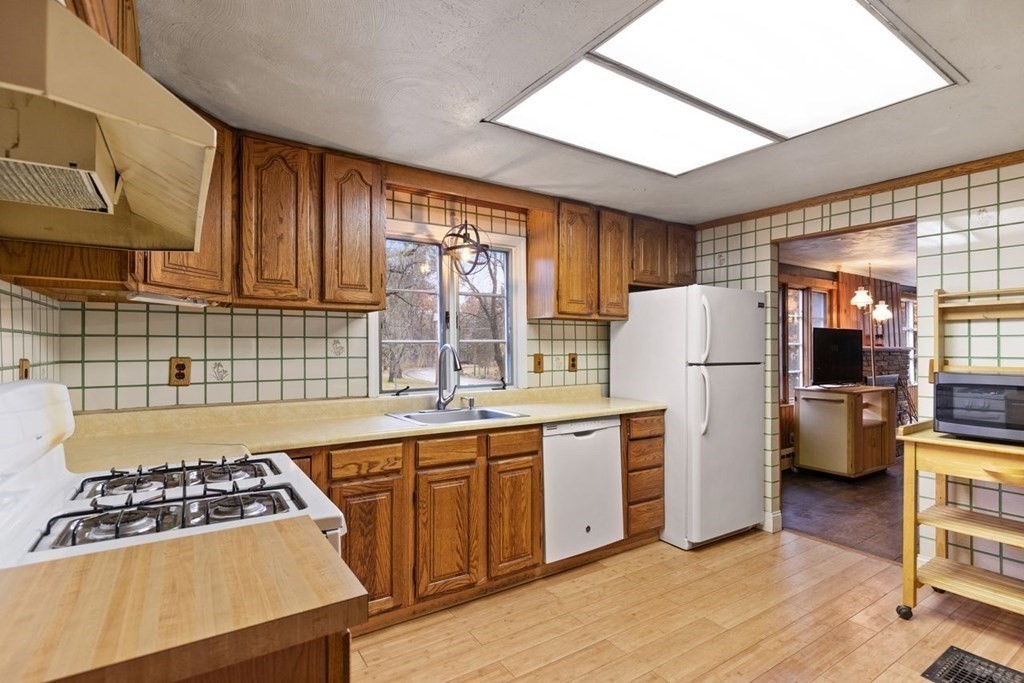 119 River Street Middleton, MA 01949 - Photo 12 of 31 a kitchen with a stove a refrigerator and wooden cabinets