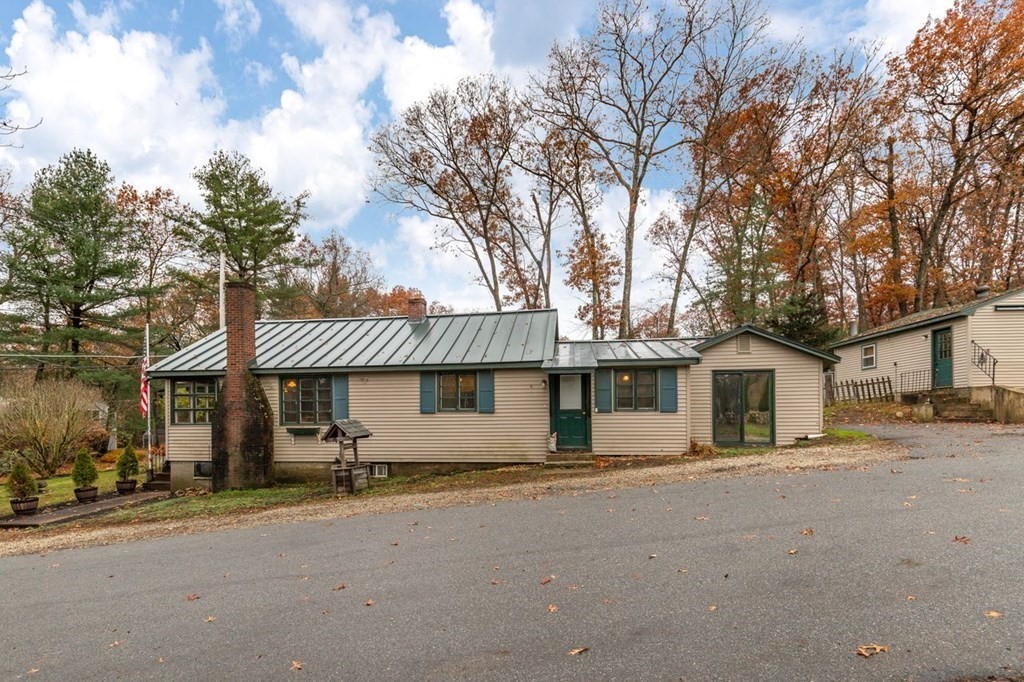119 River Street Middleton, MA 01949 - Photo 29 of 31 a front view of a house with a dirt yard and a large tree
