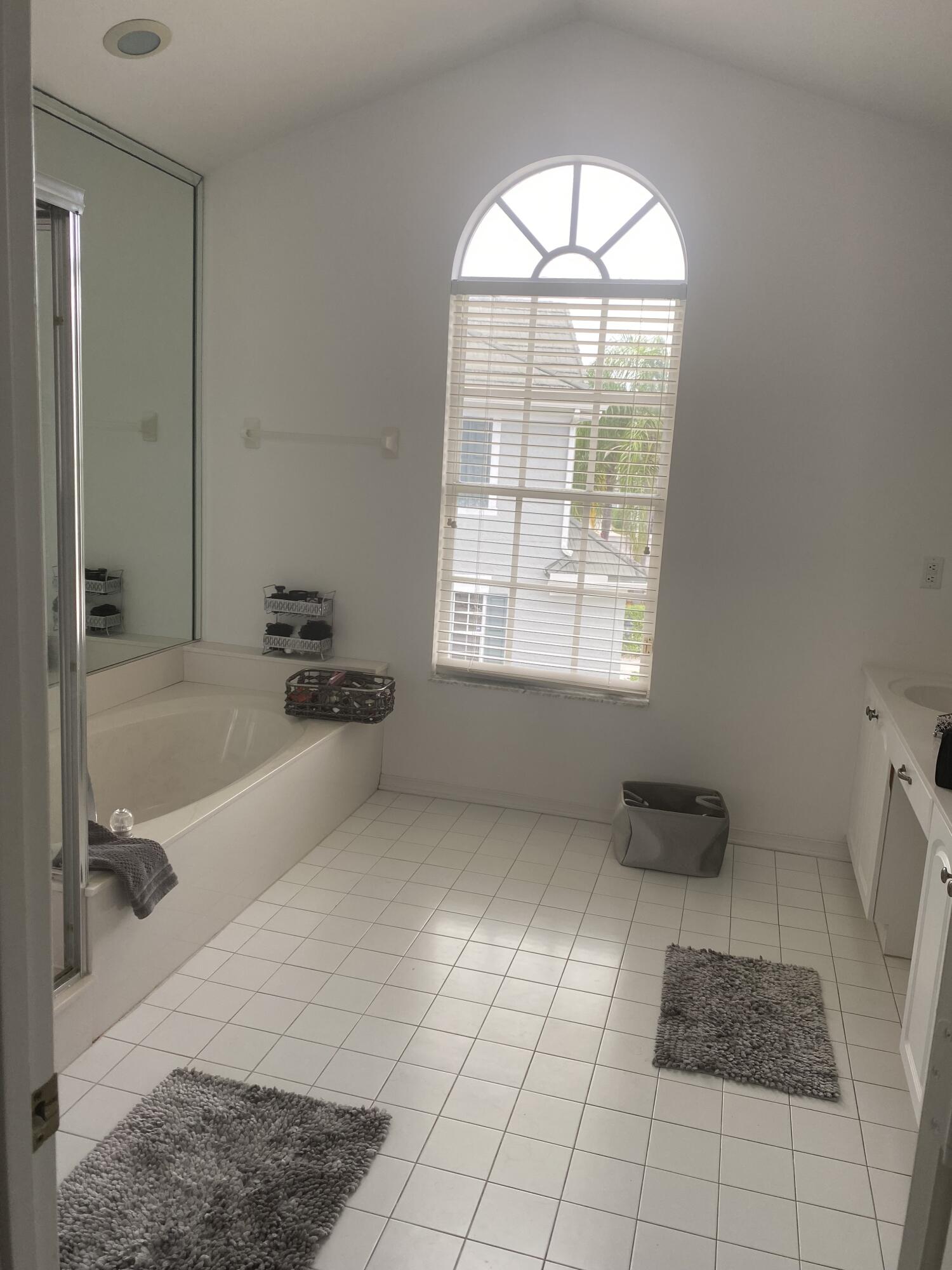 21530 St Andrews Grand Circle, Unit 27 Boca Raton, FL 33486 - Photo 13 of 18 a bathroom with a granite countertop sink a toilet and a bathtub