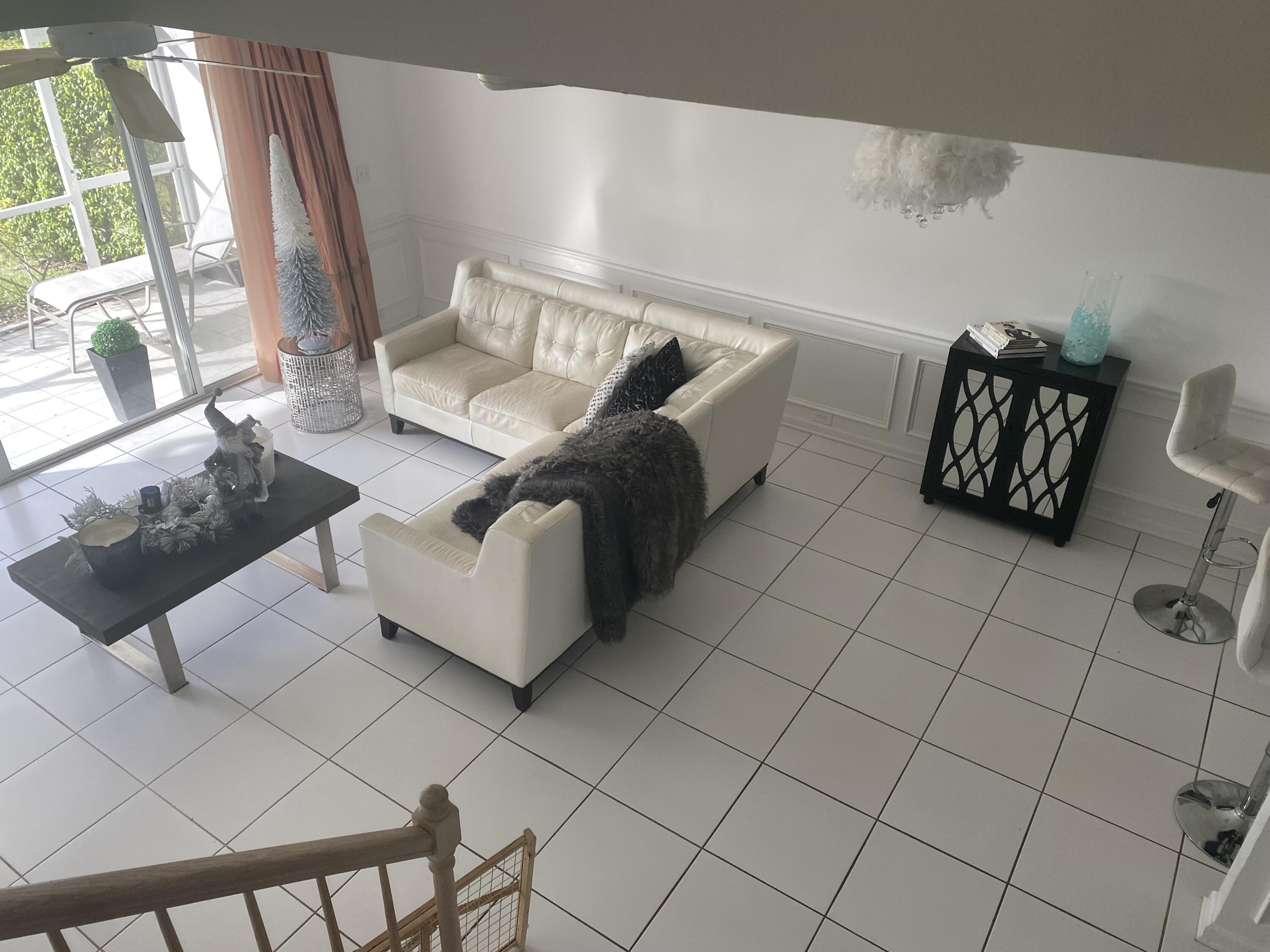 21530 St Andrews Grand Circle, Unit 27 Boca Raton, FL 33486 - Photo 8 of 18 a living room with furniture and a floor to ceiling window