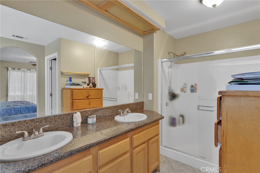 13597 Kiowa Road Apple Valley, CA 92308 - Photo 20 of 44 a bathroom with a granite countertop sink a mirror a and a shower