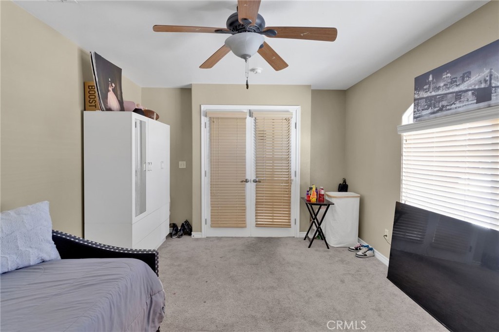 13597 Kiowa Road Apple Valley, CA 92308 - Photo 25 of 44 a bedroom with a bed and a chandelier