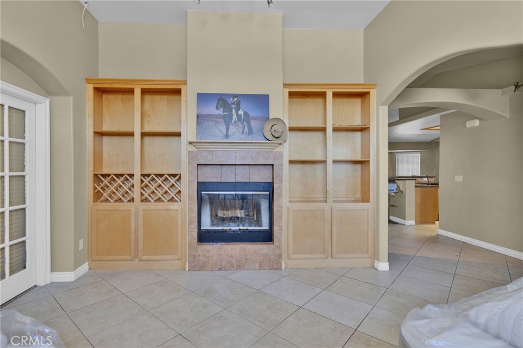 13597 Kiowa Road Apple Valley, CA 92308 - Photo 31 of 44 an empty room with a fireplace and cabinet