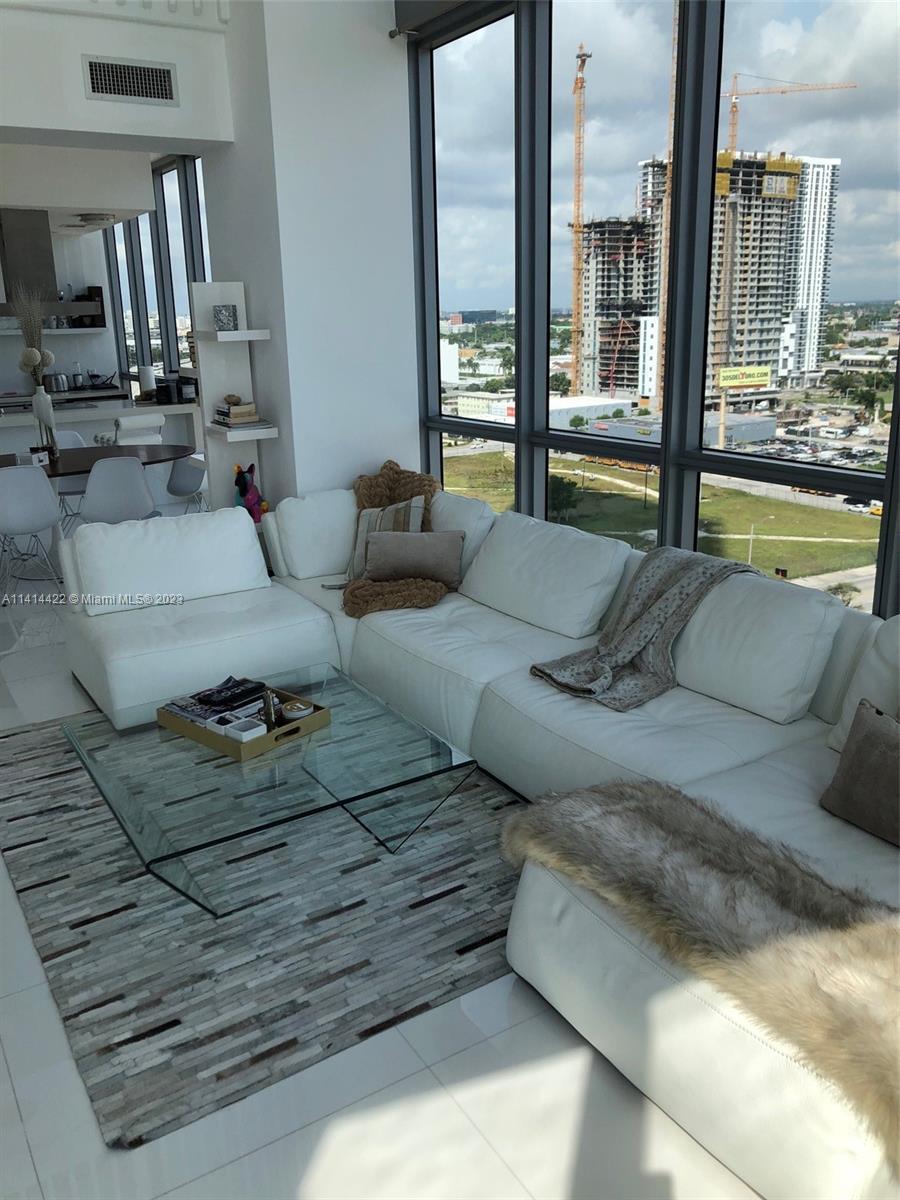 1100 Biscayne Boulevard, Unit 1505 Miami, FL 33132 - Photo 2 of 15 a living room with furniture and a floor to ceiling window