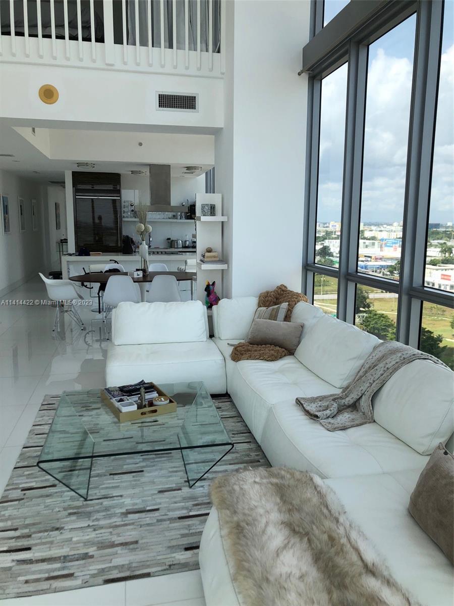 1100 Biscayne Boulevard, Unit 1505 Miami, FL 33132 - Photo 6 of 15 a living room with furniture and a floor to ceiling window