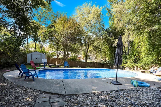a view of a house with backyard and trees