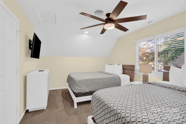 a bedroom with two beds and view of kitchen