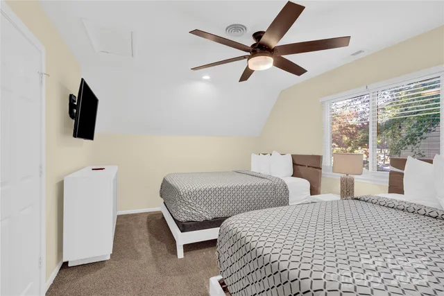 a bedroom with two beds and view of kitchen