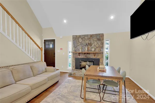 a living room with furniture a flat screen tv and a fireplace