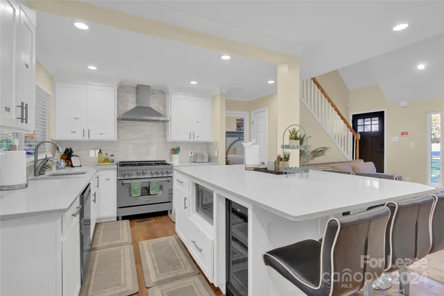 a kitchen with stainless steel appliances a stove a sink a stove a refrigerator cabinets and a dining table