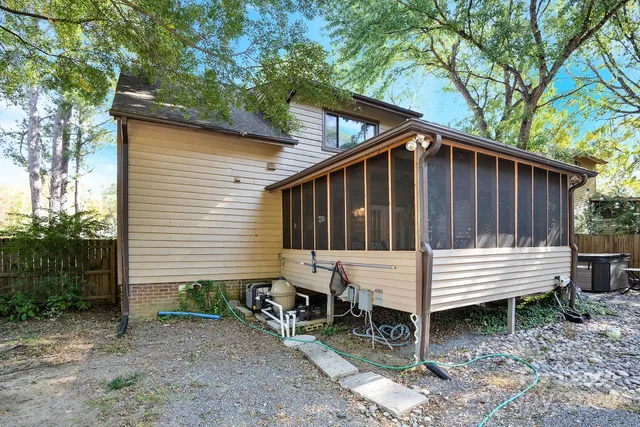 a view of a wooden bench in the back yard of a house