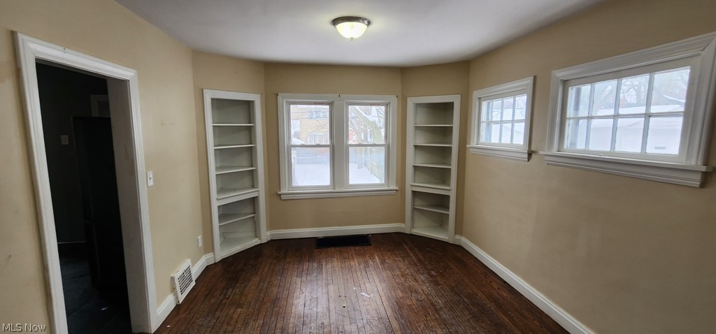3599 Grosvenor Road Cleveland, OH 44118 - Photo 2 of 25 Unfurnished dining area with baseboards and dark wood-style flooring