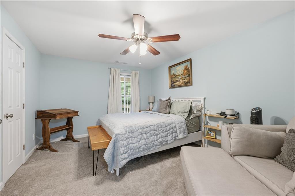 1007 Olde Mill Lane Norcross, GA 30093 - Photo 19 of 32 a bedroom with a bed and a chandelier