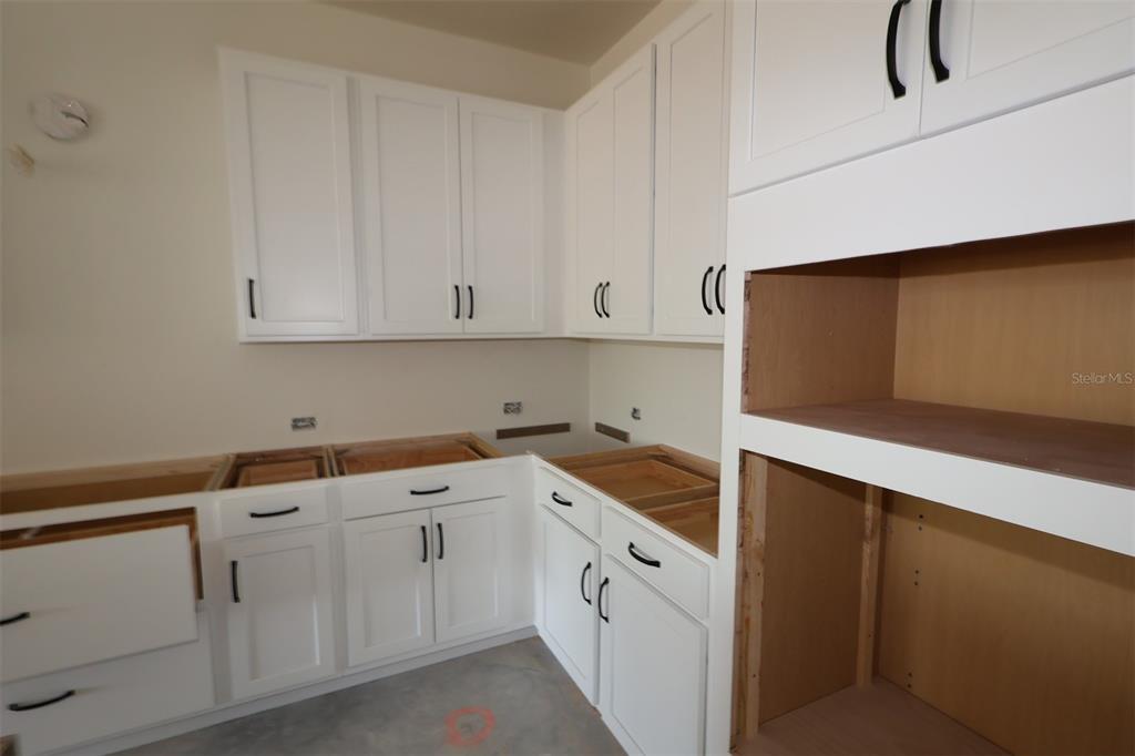 5113 Chapel Row Avenue Apollo Beach, FL 33572 - Photo 8 of 19 a kitchen with white cabinets and white appliances