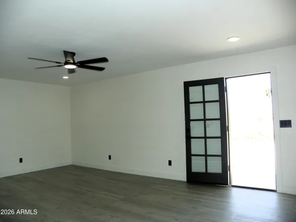 an empty room with a ceiling fan and a window