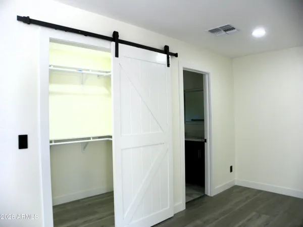 an empty room with wooden floor ceiling fan and windows