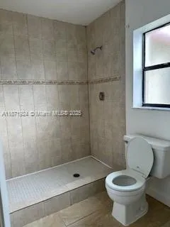 a bathroom with a toilet and a shower