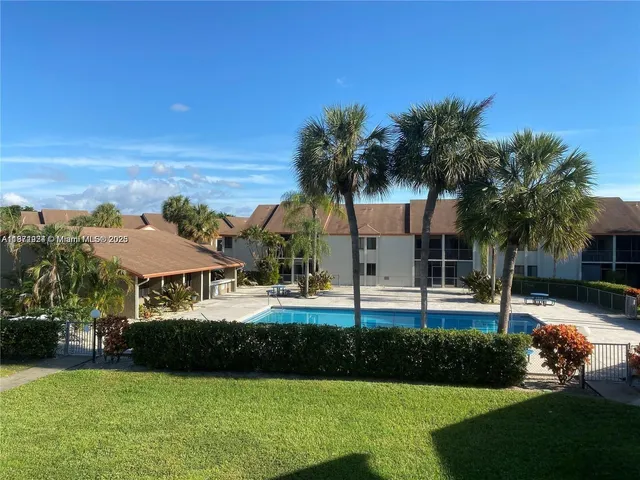 a front view of a house with garden and trees