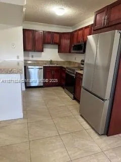 a kitchen with stainless steel appliances granite countertop a refrigerator a stove a sink and a microwave