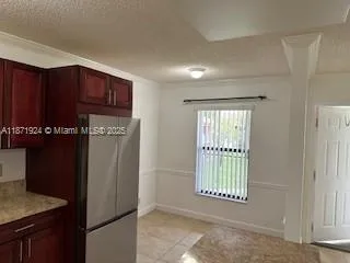 a view of an empty room with a kitchen