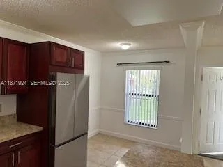 a view of an empty room with a kitchen