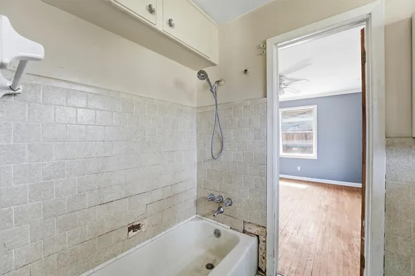 a bathroom with a tub shower vanity and a sink