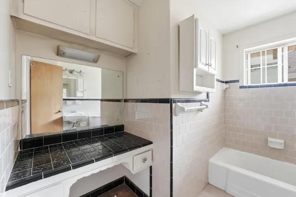 a bathroom with a granite countertop sink a toilet and bathtub