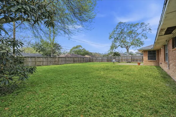 a view of a house with a big yard and large trees