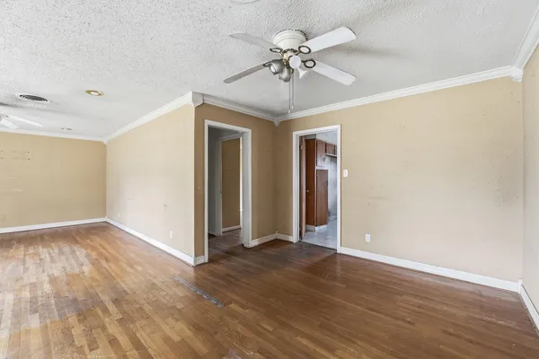a view of an empty room with wooden floor