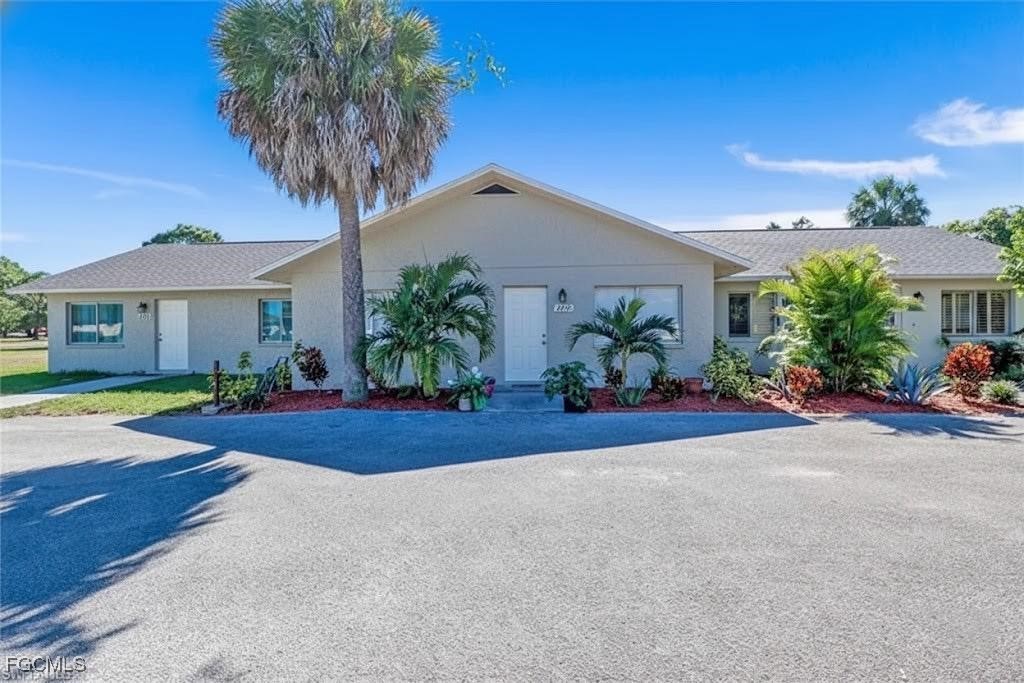 front view of a house with potted plants and a yard