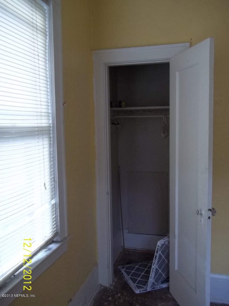 3038 Post Street Jacksonville, FL 32205 - Photo 5 of 13 a wooden door with a chair and a potted plant on a dresser