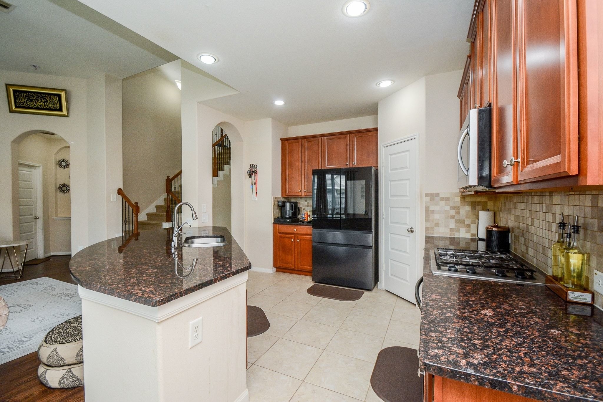 7046 Sliding Rock Circle Spring, TX 77379 - Photo 14 of 41 Discover a stylish kitchen with sleek granite countertops, modern appliances, and warm cabinetry, perfect for culinary creativity and entertaining.