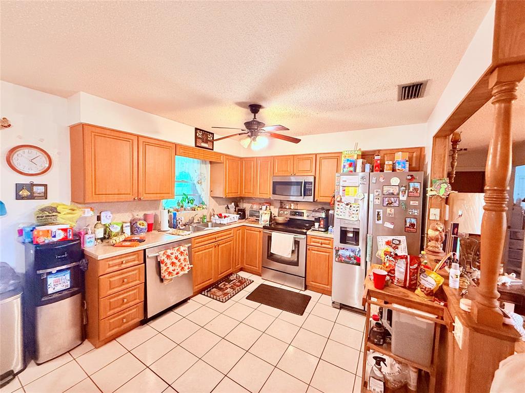 393 Southwest 72nd Terrace Okeechobee, FL 34974 - Photo 12 of 21 a kitchen with stainless steel appliances a stove top oven a sink dishwasher and cabinets with wooden floor