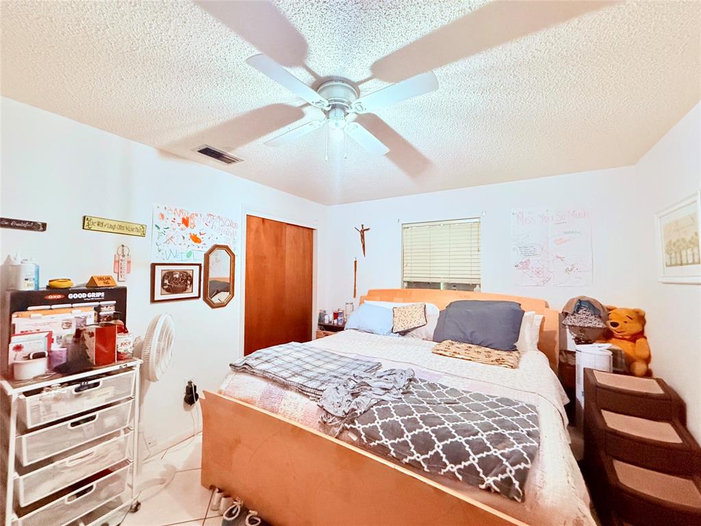 393 Southwest 72nd Terrace Okeechobee, FL 34974 - Photo 15 of 21 a bedroom with a bed and a chandelier