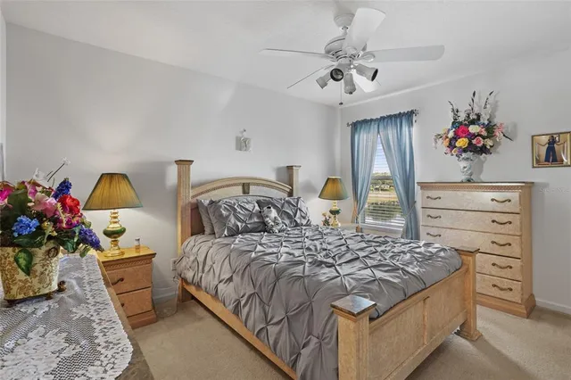 a bedroom with a bed a chandelier and dresser
