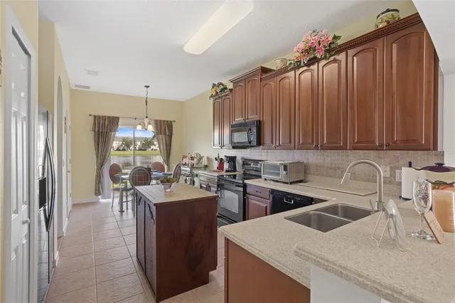 a kitchen with a sink a stove and chairs