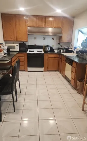 a kitchen with stainless steel appliances granite countertop a stove a sink a counter space and cabinets
