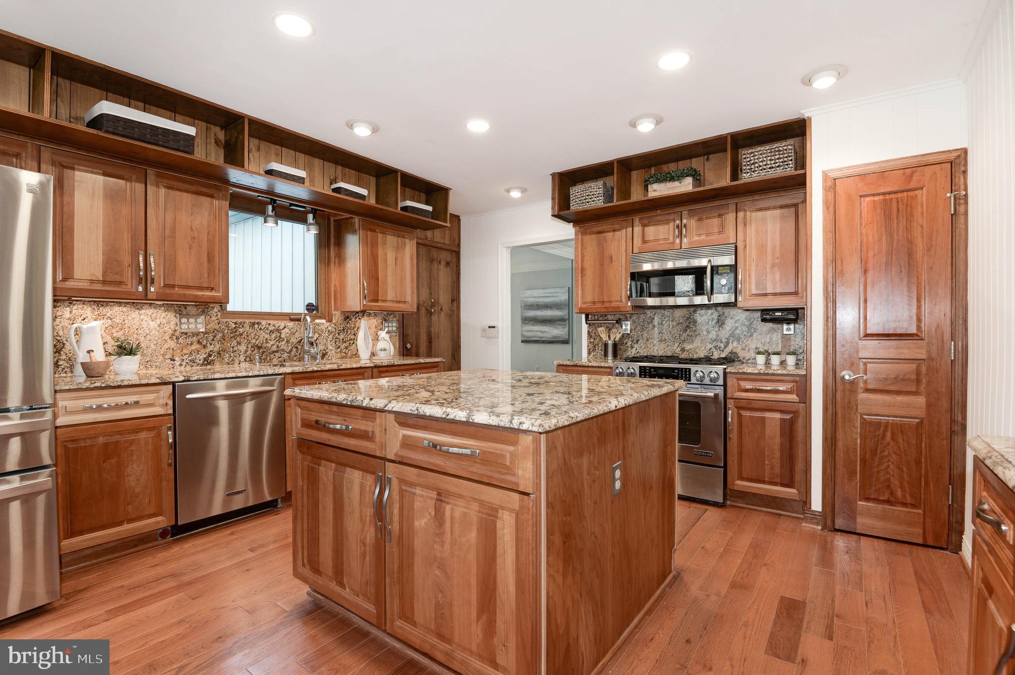 11805 Blue Spruce Road Reston, VA 20191 - Photo 26 of 74 a kitchen with stainless steel appliances kitchen island granite countertop a stove a sink and a refrigerator