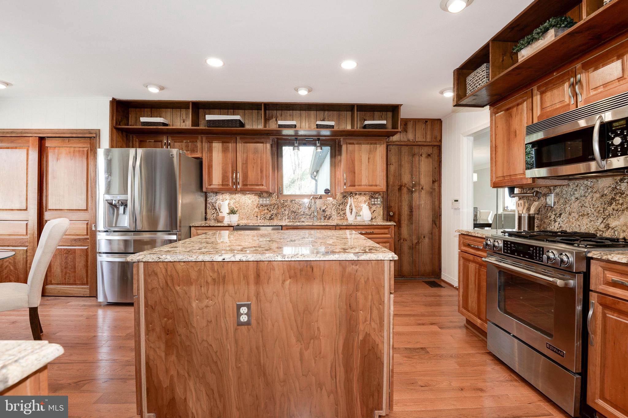 11805 Blue Spruce Road Reston, VA 20191 - Photo 33 of 74 a kitchen with kitchen island granite countertop a stove and a refrigerator