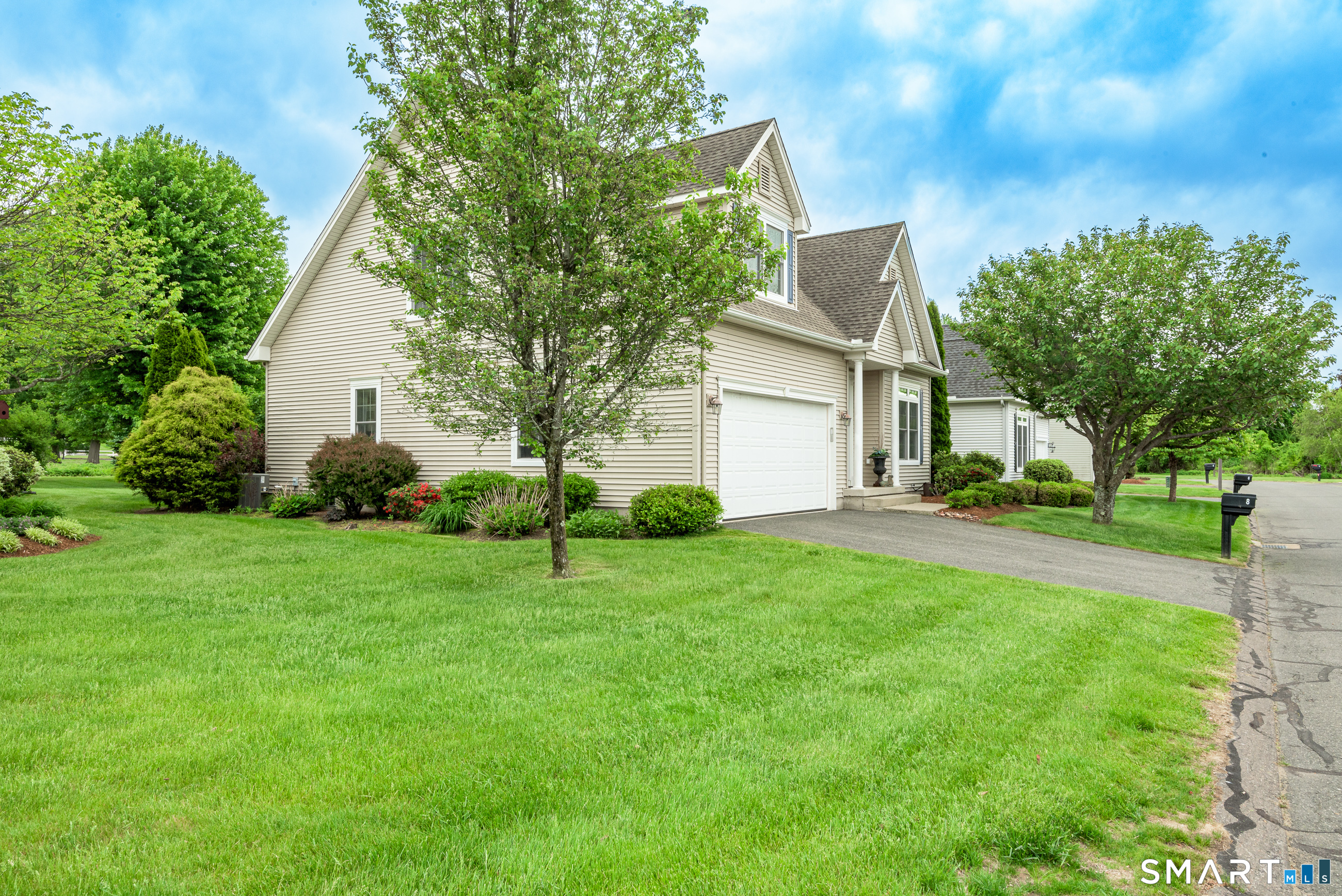 8 Greendale Drive, Unit 8 Suffield, CT 06078 - Photo 2 of 40 a front view of a house with a yard and trees