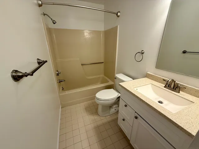 a bathroom with a double vanity sink toilet mirror and shower