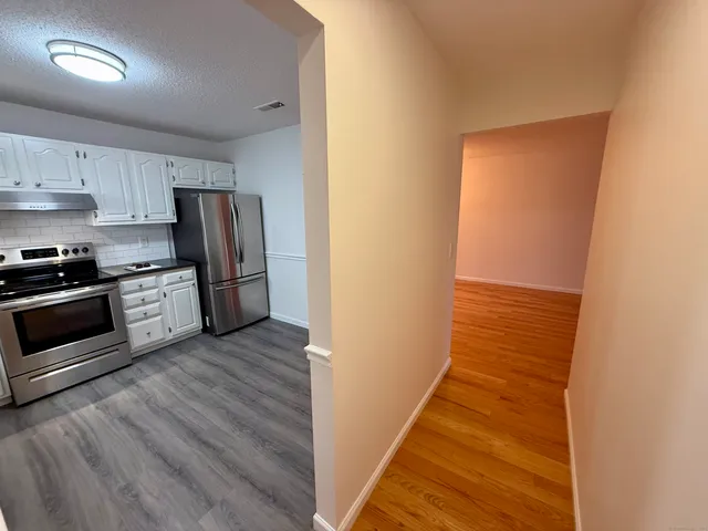 a kitchen with stainless steel appliances a refrigerator and a stove top oven