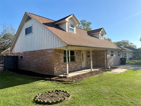 a front view of a house with a garden and yard