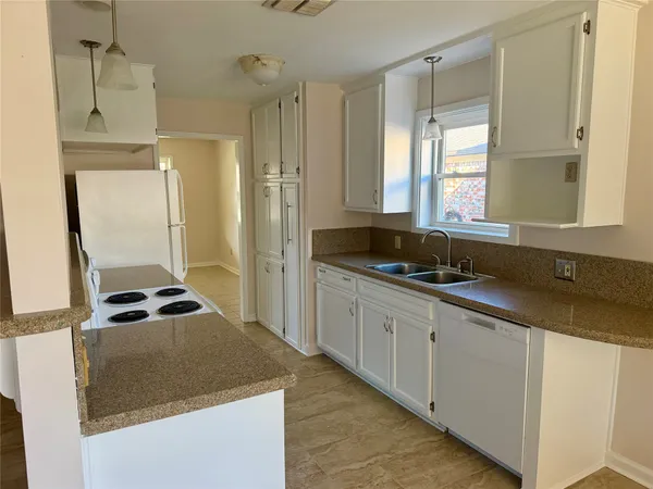 a kitchen with granite countertop a sink and a stove